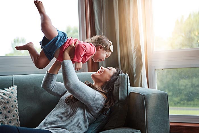 mom lifting laughing baby in the air